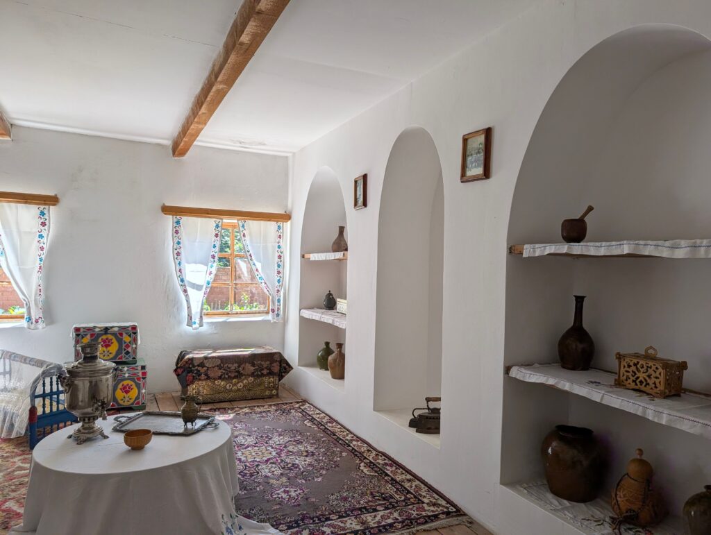 Cozy traditional room with elegant decor, featuring colorful textiles and antique furnishings.