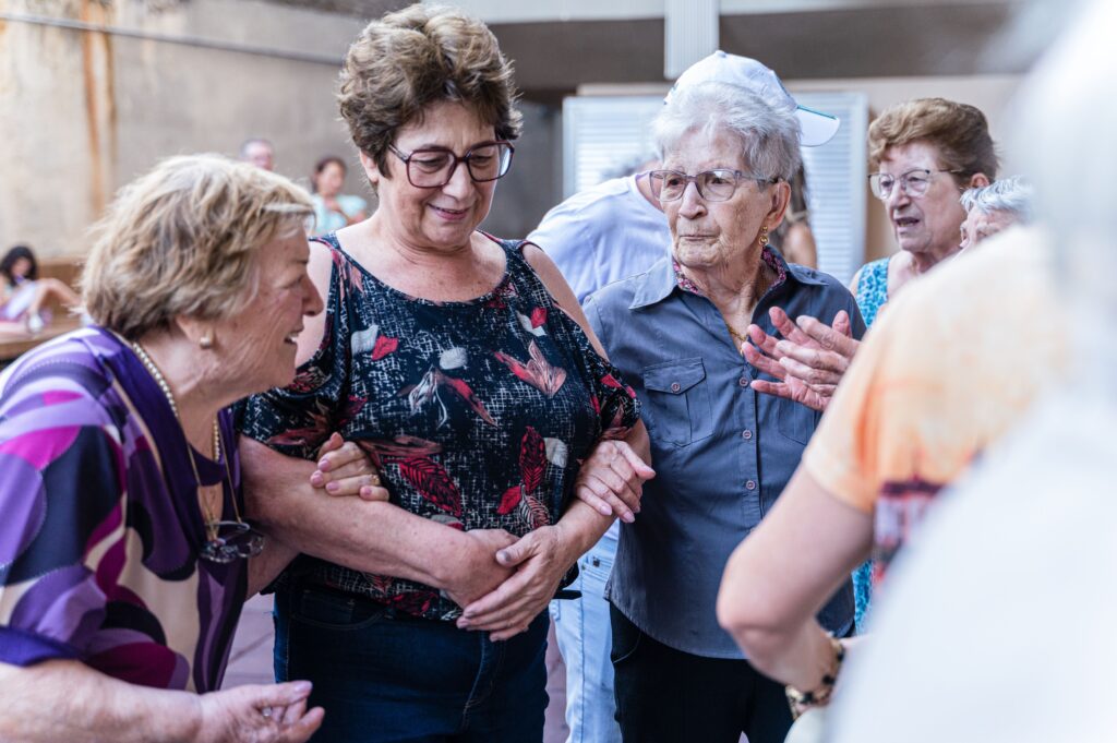 Elderly women enjoying a joyful indoor gathering, sharing smiles and companionship.